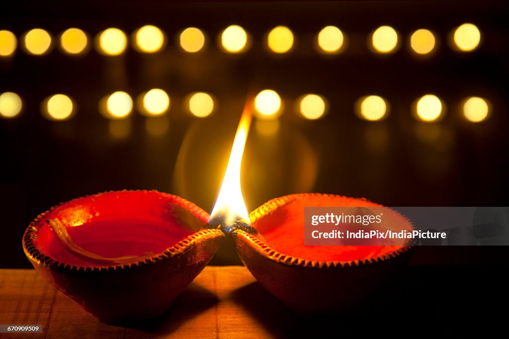 Two earthen lamps lit for festival