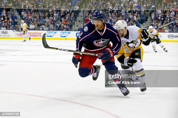 Seth Jones of the Columbus Blue Jackets and Bryan Rust of the Pittsburgh Penguins chase after the puck in Game Four of the Eastern Conference First...