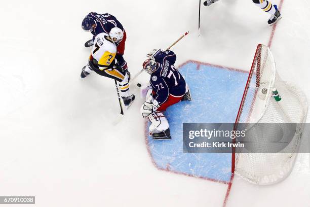 Lukas Sedlak of the Columbus Blue Jackets checks Matt Cullen of the Pittsburgh Penguins as Sergei Bobrovsky of the Columbus Blue Jackets makes a save...