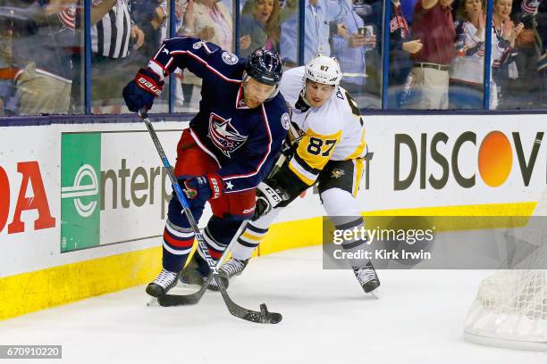 Jack Johnson of the Columbus Blue Jackets and Sidney Crosby of the Pittsburgh Penguins battle for control of the puck in Game Four of the Eastern...