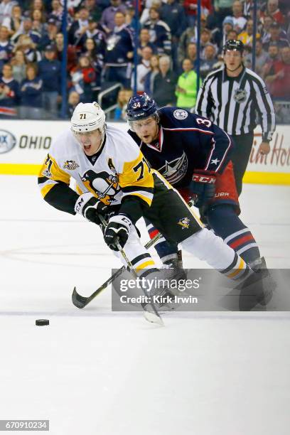 Evgeni Malkin of the Pittsburgh Penguins skates the puck away from Josh Anderson of the Columbus Blue Jackets in Game Four of the Eastern Conference...