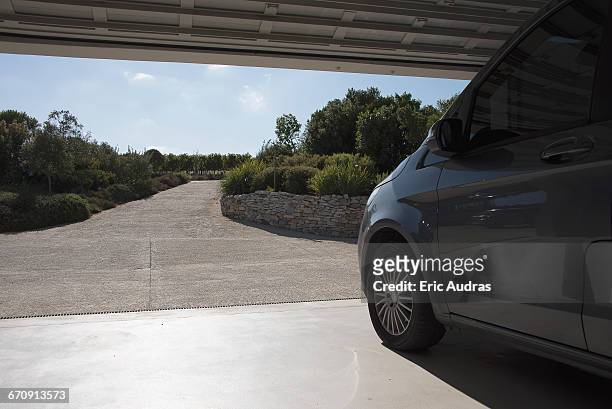 car in garage leading toward driveway - garage driveway stock pictures, royalty-free photos & images