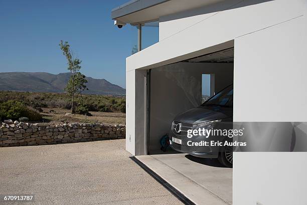 exterior of modern car garage - car in driveway stock-fotos und bilder