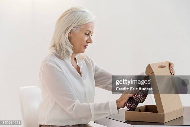 side profile of a woman opening a parcel of sandal - shoes box stock-fotos und bilder