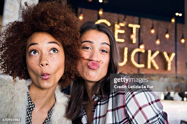 portrait of happy female friends having fun in cafe - puckering ストックフォトと画像