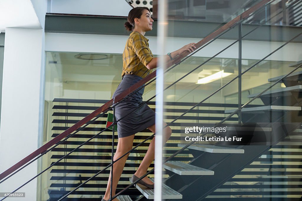 Businesswoman ascending office staircase