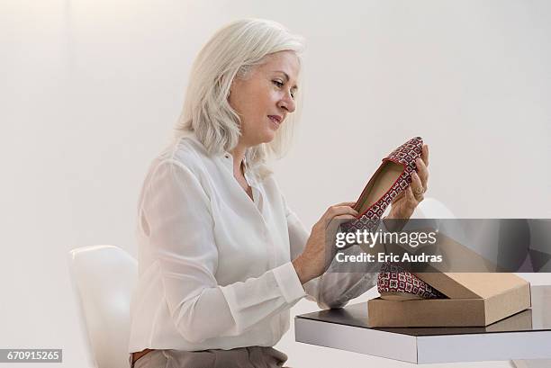 side profile of a mature woman looking at sandals - shoes box stock pictures, royalty-free photos & images