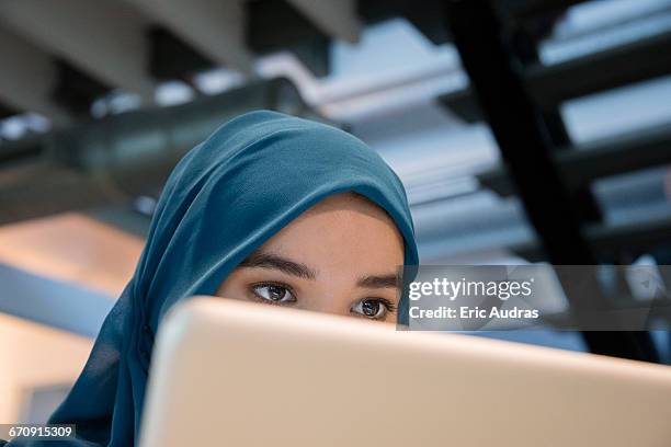 arab businesswoman using a laptop - hijab stock pictures, royalty-free photos & images