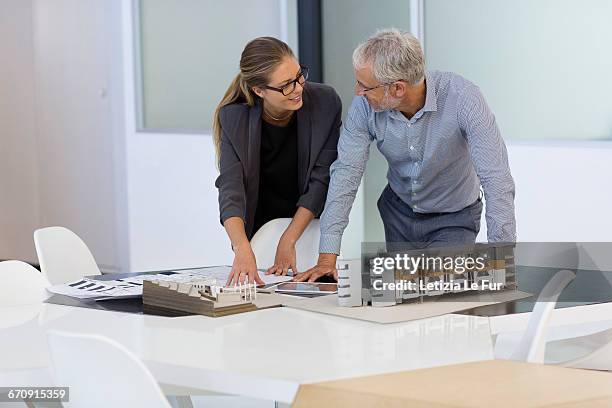 design professionals examining architectural model in an office - architekturmodell stock-fotos und bilder