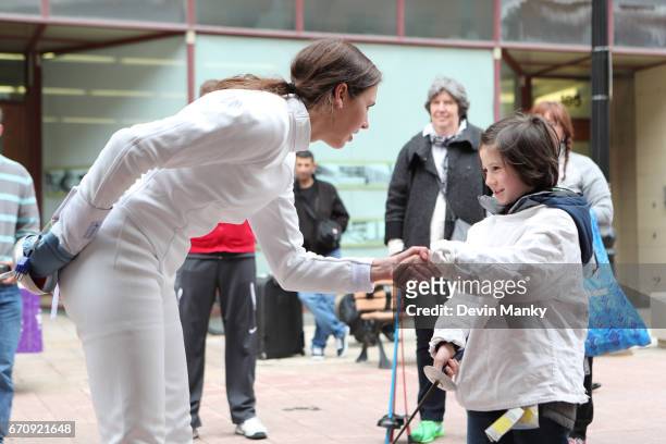 Canadian Modern-Pentathlon Olympian Melanie McCann shakes the hand of a young opponent after they fence during an outdoor fencing demonstration on...