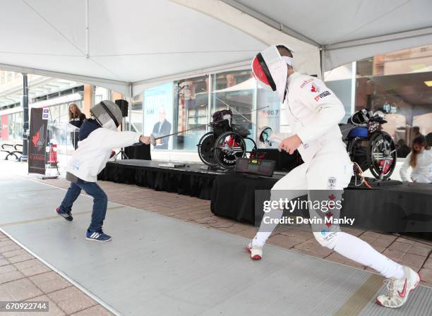 Canadian Fencing Olympian Maxime Brinck-Croteau fences a young opponent during an outdoor fencing demonstration on Sparks Street during the Medley on...