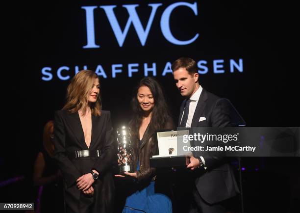 Filmmaker Chloe Zhao receives an award from actress Rosamund Pike and CEO of IWC Schaffhausen Christoph Grainger-Herr on stage during the exclusive...