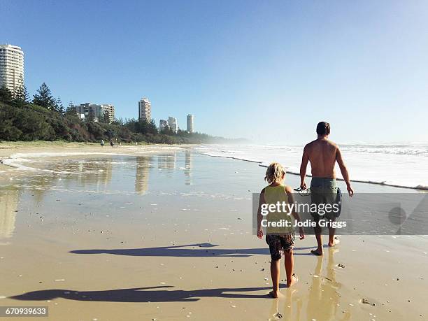 father and daughter walking down the beach - shadow following stock pictures, royalty-free photos & images