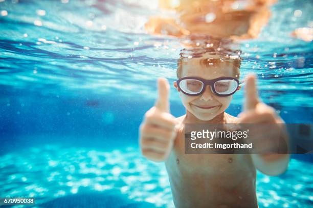 little boy in pool showing thumbs up - swimming goggles stock pictures, royalty-free photos & images