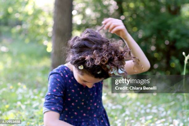 little girl plays in nature - capelli ricci 個照片及圖片檔