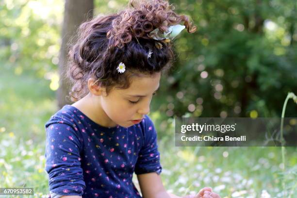 little girl plays in nature - capelli ricci 個照片及圖片檔