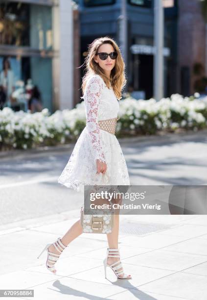 Model and fashion blogger Alexandra Lapp wearing a white Zouze dress, waist belt in beige and white leather from Azzedine Alaia, white sandals from...