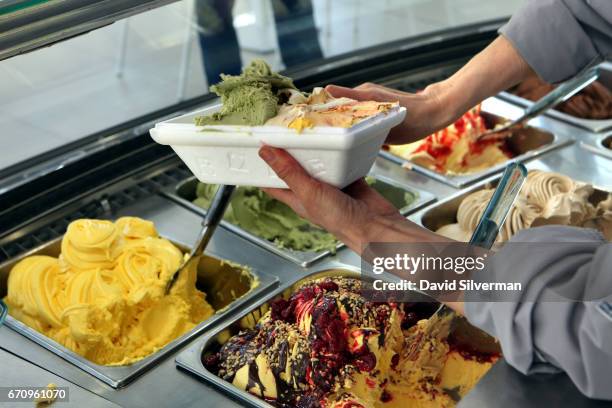 Server prepares a take-away selection of freshly-made Italian gelato ice-cream at the Carpigiani company's on-site gelateria on March 28, 2017 in...