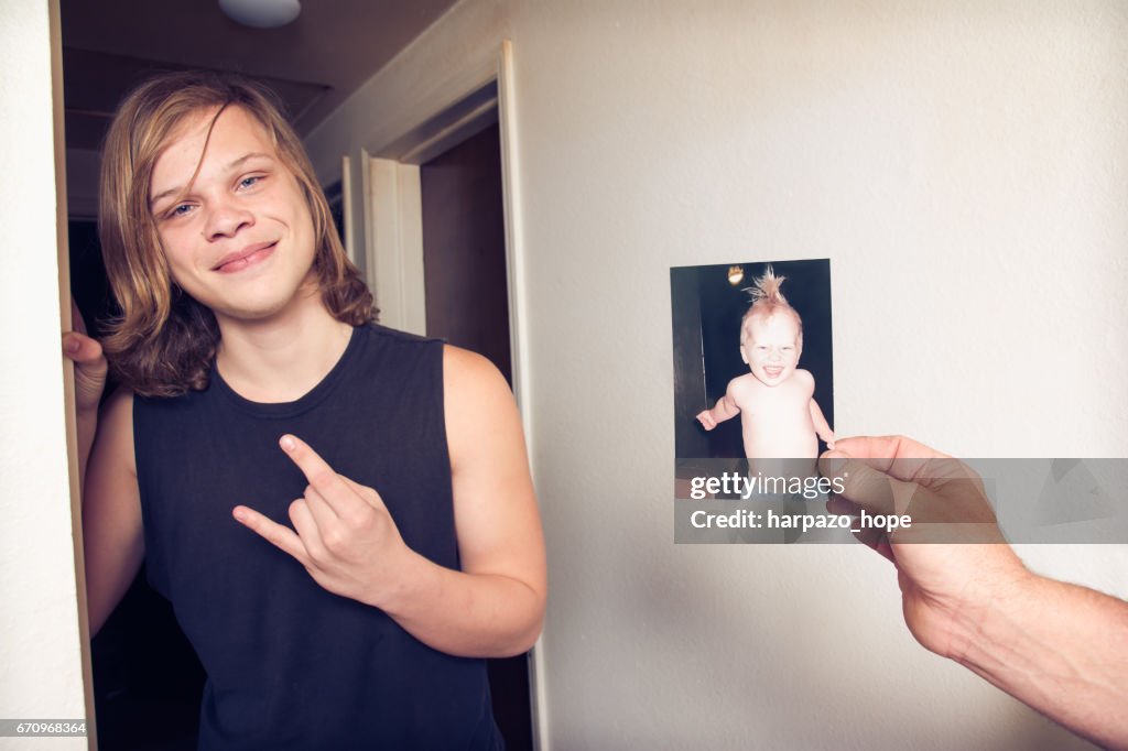 Teenage boy next to a photo of himself as a toddler.