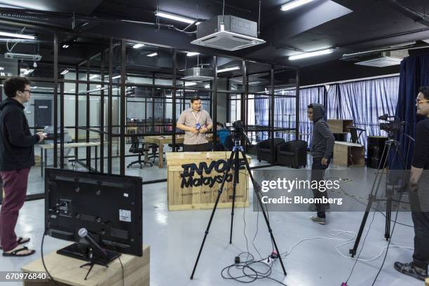 Rafizi Ramli, vice president of the People's Justice Party , center, prepares for a Facebook Inc. Live video stream at Invoke's office in Kuala...