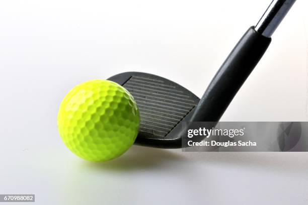 close-up of a neon golf ball and iron golf club - klöver nummerkort bildbanksfoton och bilder