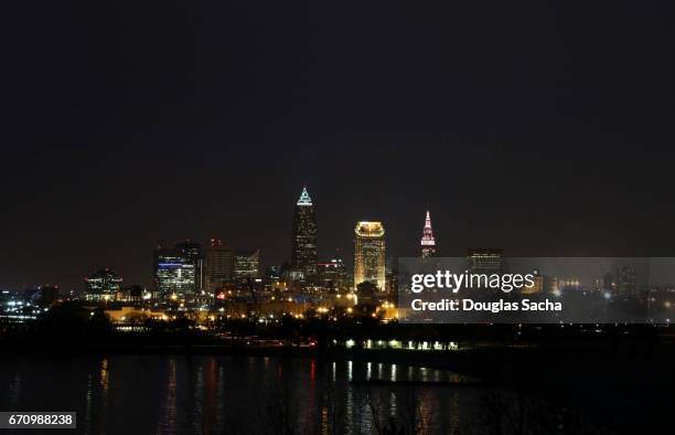 illuminated cleveland skyline at night - cleveland ohio flats stock pictures, royalty-free photos & images