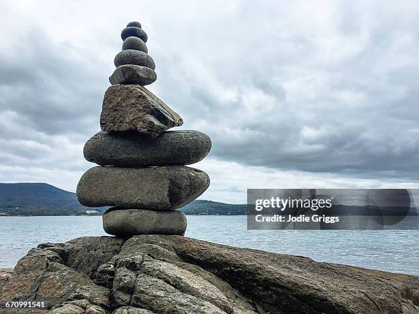 stack of pebbles balanced on rock by the beach - bruny island stock pictures, royalty-free photos & images