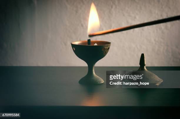 long match lighting an incense cone. - incense stock-fotos und bilder