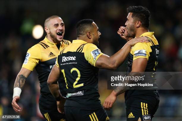 Vince Aso of the Hurricanes celebrates his try with teammates TJ Perenara and Ngani Laumape during the round nine Super Rugby match between the...