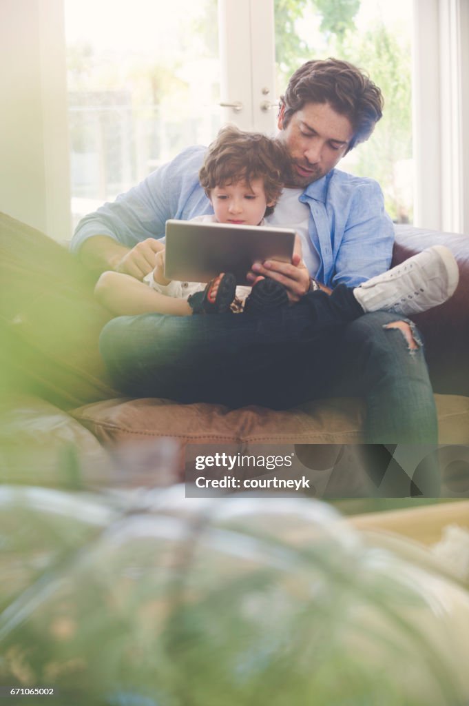 Vater und Sohn mit einem digitalen Tablet zusammen.