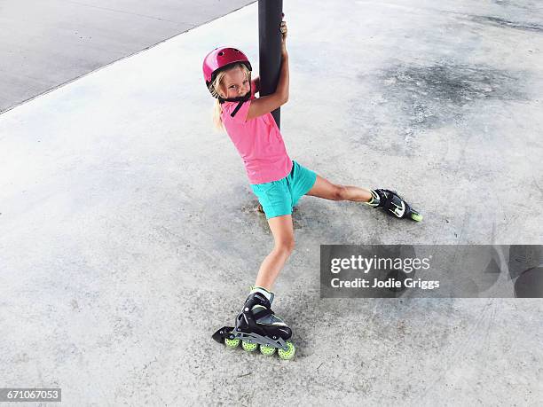 child learning how to ride inline skates - rolschaatsen schaats stockfoto's en -beelden