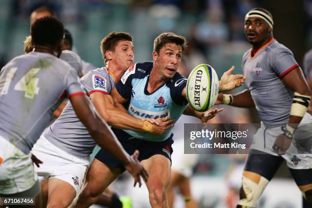 Jake Gordon of the Waratahs offloads the ball in a tackle during the round nine Super Rugby match between the Waratahs and the Kings at Allianz...