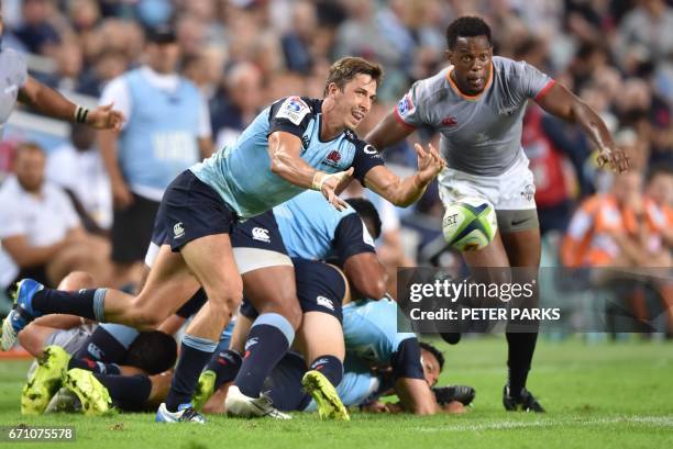 Waratahs player Jake Gordon clears the ball as Wandiler Mjekevu of the Southern Kings looks on during the Super15 rugby match between Waratahs and...