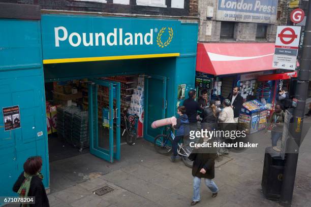 Boy on a bike holds an inflatable penis outside a Poundland on the Walworth Road, on 31st March 2017, in south London, England.