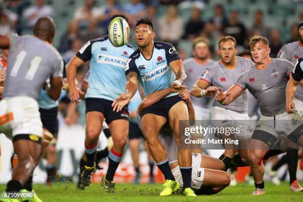 Israel Folau of the Waratahs offloads the ball in a tackle during the round nine Super Rugby match between the Waratahs and the Kings at Allianz...