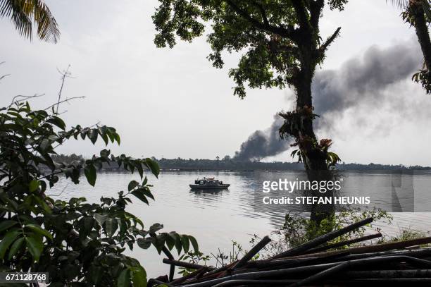 Cloud of smoke rises from an illegal oil refinery on April 19, 2017 in the Niger Delta region near the city of Port Harcourt. NNS Pathfinder of the...