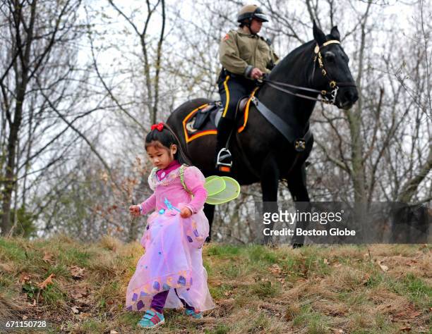 Five year old Enyi Zhang from Burlington watches her step, while a horseback park ranger stands in the background, at Franklin Park in Boston on Apr....