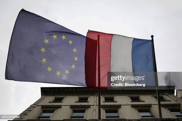 European Union flag, left, and a French flag fly outside the French consulate in London, U.K., on Friday, April 21, 2017. Three days before the first...