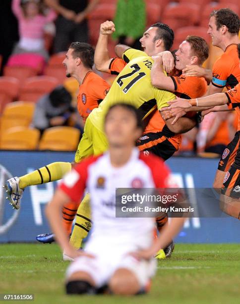 Roar players celebrate victory after a shoot out in extra time as Jumpei Kusukami of the Wanderers looks dejected after missing his shot at goal...