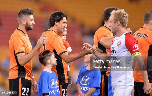Thomas Broich of the Roar is seen with his young child as he shakes hands with Mitch Nichols of the Wanderers before the start of the A-League...