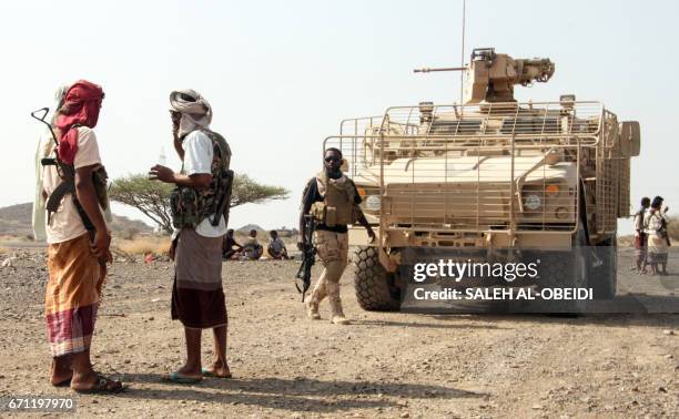 Yemeni fighters loyal to the Saudi-backed Yemeni president stand by armoured vehicles at a position which was taken from Shiite-Huthi rebels in a...