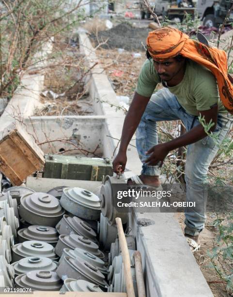 Yemeni fighter loyal to the Saudi-backed Yemeni president holds a landmine at a position which was taken from Shiite-Huthi rebels in a mountainous...