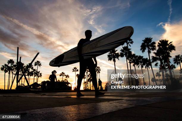 venice beach bei sonnenuntergang - low angle view of silhouette palm trees against sky stock-fotos und bilder