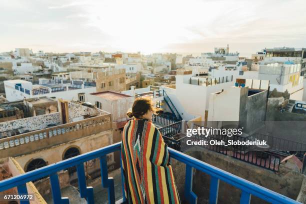 frau betrachten vom dach in essaouira - essaouira stock-fotos und bilder
