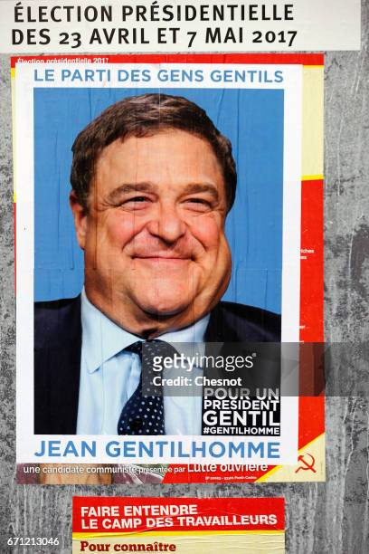 Poster with the face of actor John Goodman is fixed over the official poster of French presidential election candidate for the far-left "Lutte...