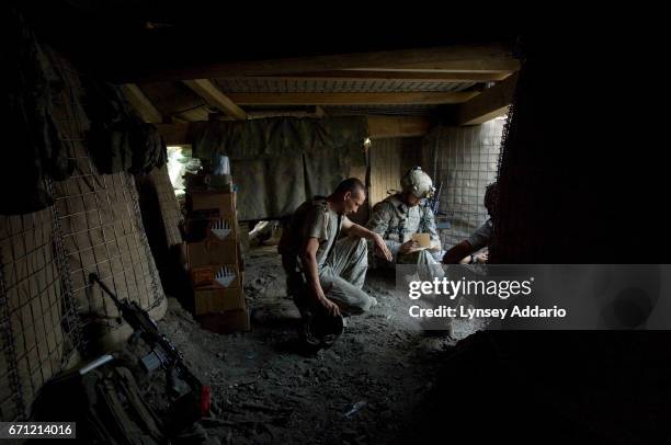 Battle Company troops rest inside a bunker of a new outpost his platoon fought hard to establish after the Taliban had controlled this strategic high...