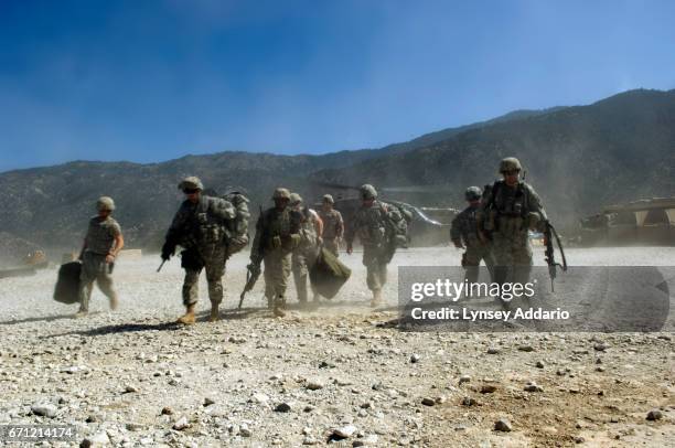 Captain Dan Kearney, far right, walks with other soldiers from the 173rd division, battle company, off of a blackhawk and to the KOP base in the...