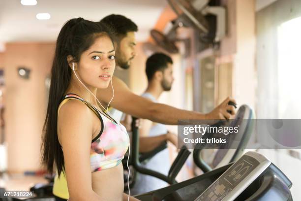 young woman on treadmill at gym - cardiovascular exercise stock pictures, royalty-free photos & images
