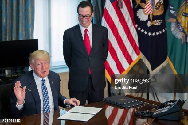 President Donald Trump , with Secretary of Treasury Steven Mnuchin , participate in a financial services Executive Order signing ceremony in the US...