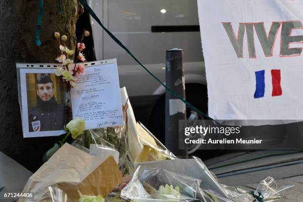 Photo of the fallen police officer is placed with flowers on the Champs Elysees the day after a gunman opened fire on police officers on April 21,...